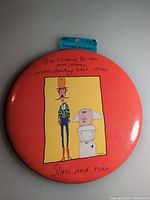 Full view of large red round pin with cartoon and caption