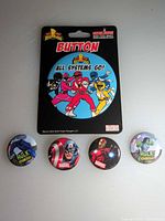 Group shot of all five pinback buttons including carded Power Rangers and four loose Marvel buttons