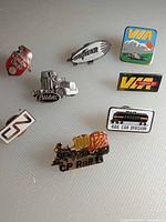 All eight transportation-themed enamel pins laid out