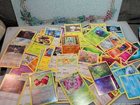 Spread of mixed Pokémon cards showing variety of commons, uncommons, rares and foils