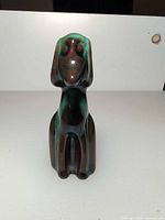 Front view of stylized ceramic dog with green drip glaze