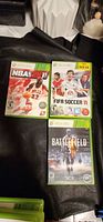 Front view of three Xbox 360 game cases: NBA 2K11, FIFA Soccer 11, Battlefield 3