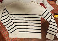 Full view of cream sweater with navy stripes and long sleeves