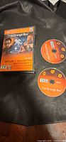 Front view of The Orange Box PC game case alongside Disc 1 and Disc 2