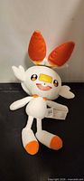 Full view of Scorbunny plush laying flat