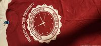 Front of red T-shirt showing clock graphic and text