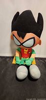 Front view of Robin plush seated upright showing costume and facial details