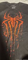 Full view of T-shirt front showing orange spider logo graphic
