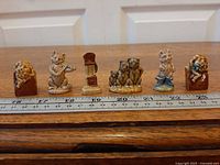 All six Wade Nursery Rhyme figurines lined up beside ruler