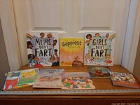 All eight softcover children’s books displayed upright and flat for full view of covers