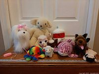 Group shot of all nine plush toys on table with ruler for scale