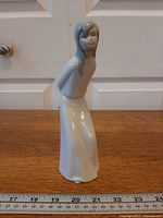 Front view of porcelain girl figurine with ruler for scale