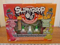 Front view of unopened Slimygloop 2-in-1 Sweet-Scented Slime Kit showing contents through window