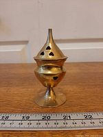 Front view of brass incense burner on pedestal
