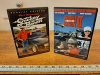 Both DVD cases upright in full view with ruler for scale