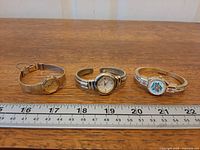 Three watches side-by-side with ruler for scale