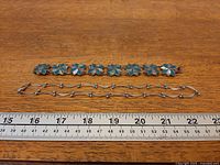Bracelet and necklace laid flat beside ruler for scale