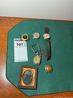 group shot of five watches and tintype photo