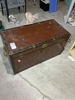 Top and side view of brown metal trunk showing overall size and wear