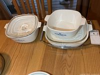 All three casserole dishes stacked with two lids and chrome stand