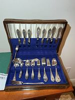 Chest open showing knives, spoons, forks in blue felt