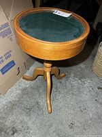 Full view of wooden round display table with glass top