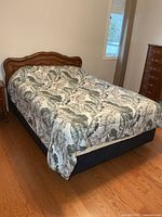 Full view of queen bed showing wooden headboard and metal frame (mattress present but not included)