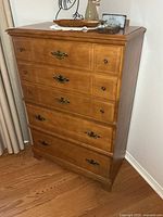 Front view of solid wood dresser showing five drawers and hardware