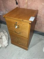 Front view showing two drawers, lock, key, brass hardware, auction sticker