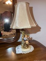 Full lamp on dresser showing shade and figurine