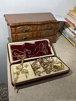 Overall lot showing wood chest, travel case and jewelry contents