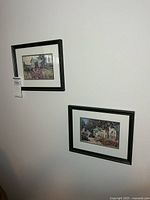 Both framed prints hanging side by side on wall