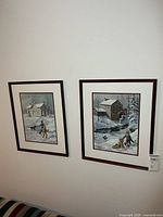 Both framed Keirstead prints hanging on wall