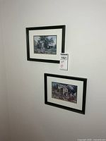 Both framed prints hanging on wall