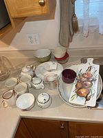 Overview of assorted mugs, platters, bowls and pitcher on countertop