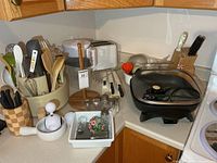 Overall lot on countertop showing skillet, toaster, utensils, Brita, cutlery, shakers
