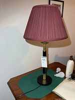 Full view of table lamp on surface showing shade, column and base