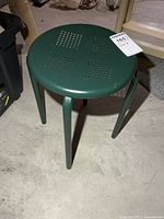 Angled view of green metal stool