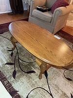 Top view of oval oak coffee table on rug