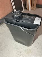 Full view of shredder head resting atop black bin with power cord visible