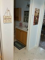 View of doorway showing wooden sign and canvas print on walls