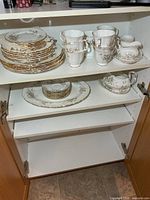 Overall view of dinnerware set in cabinet