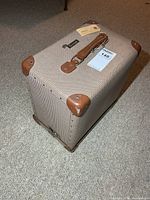 Side view of checked hard case with leatherette corners