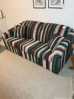 Front view of striped upholstered sofa bed with cushions