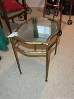 Perspective view of gold-tone metal table showing mirrored top and frame