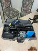 Toolbox opened showing heat gun, charger, bits