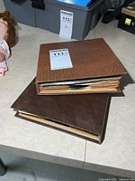 Two brown binder albums closed on tabletop