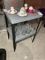 Front view of grey two-tier metal table with black legs
