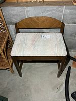Front view of wooden stool showing fabric seat and backrest