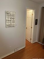 Wide view showing Serenity Prayer sign on wall, framed angel plaque by door, small love quote plaque on floor